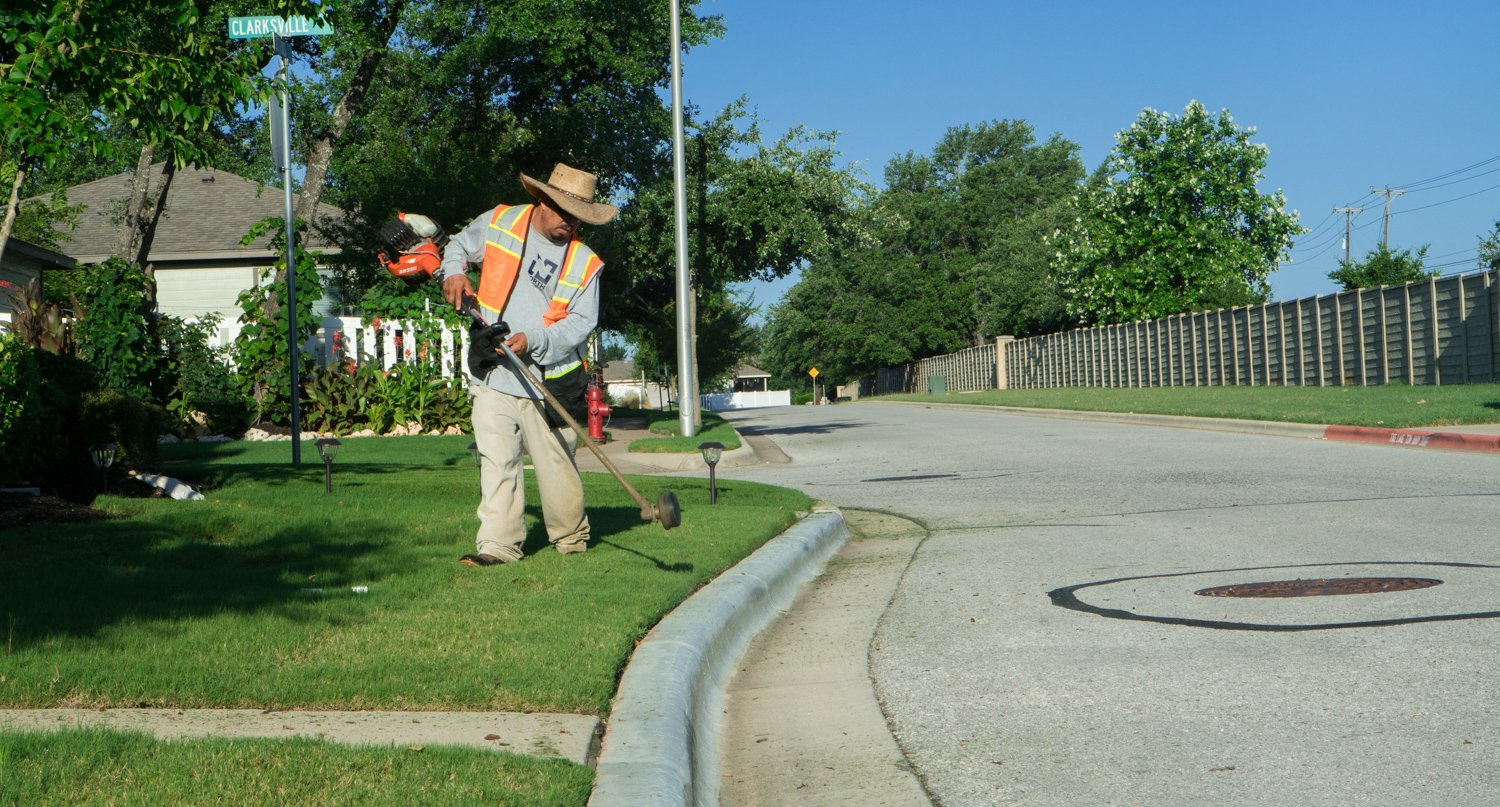 commercial landscaper trimming