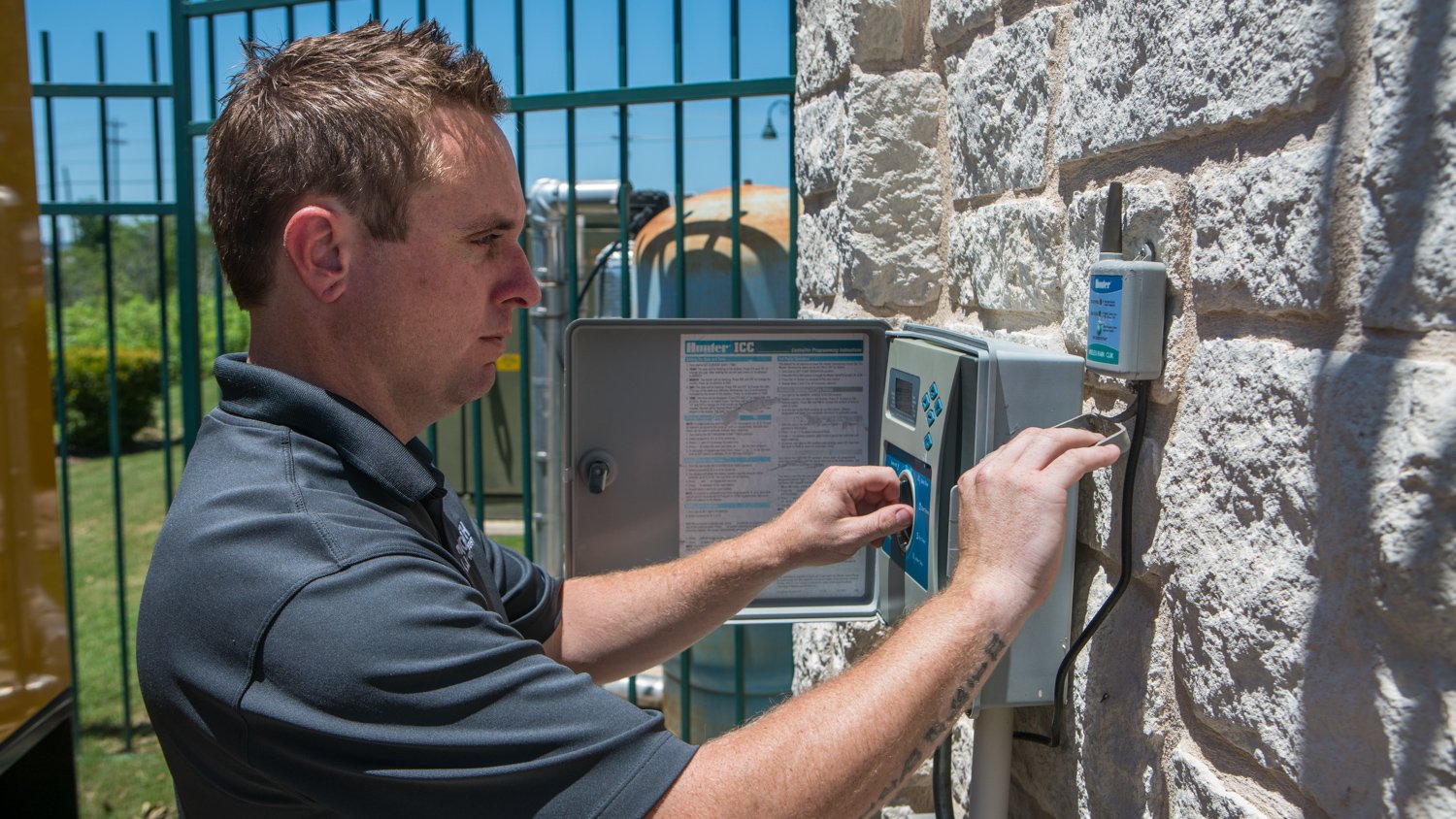 Irrigation technician checking control panel and run times