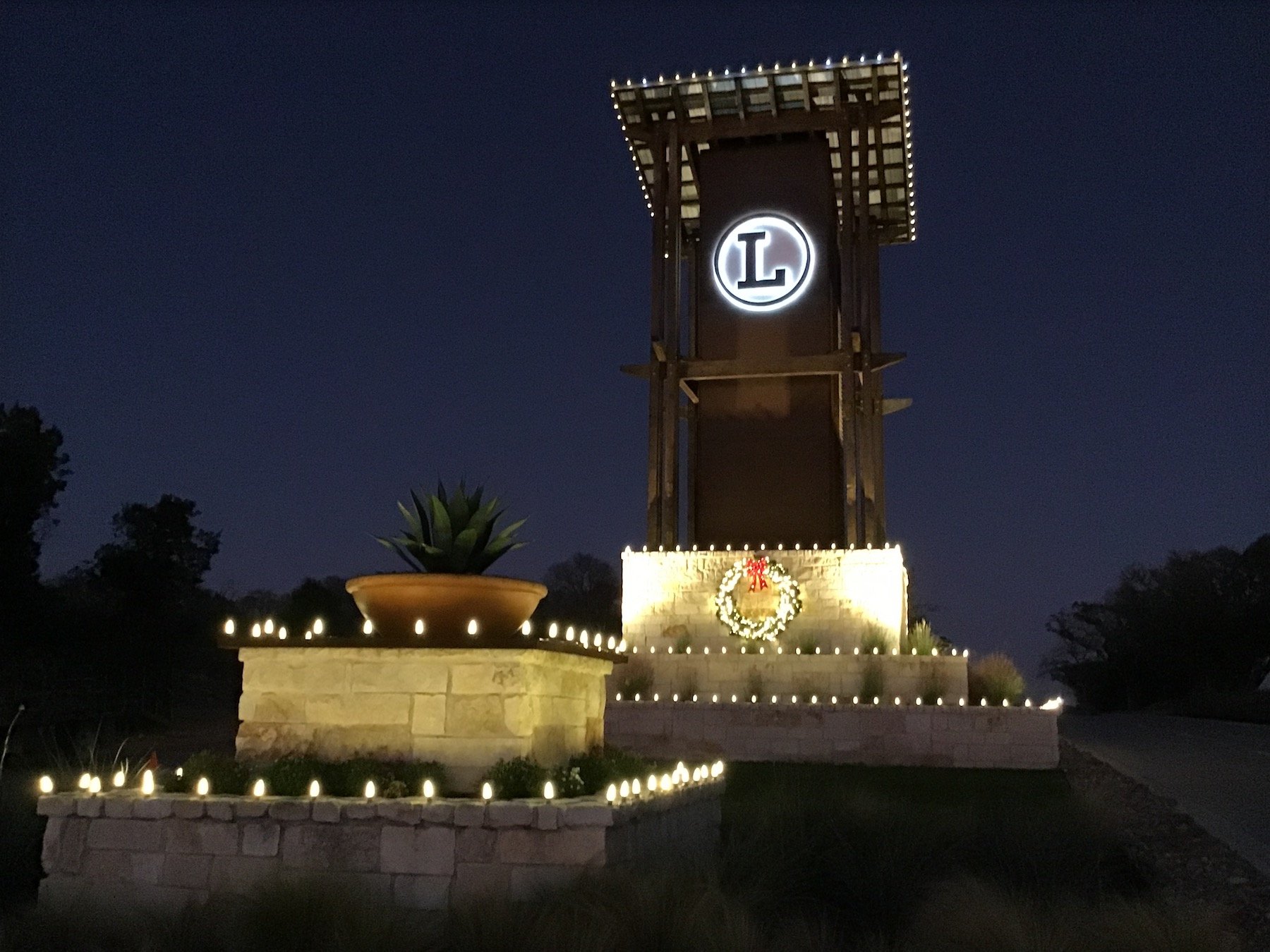 HOA Entrance holiday lighting with white lights and a wreath