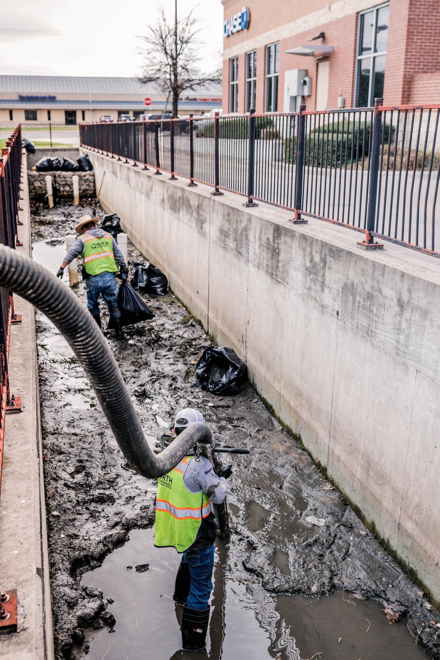 landscapers removing trash from detention basin