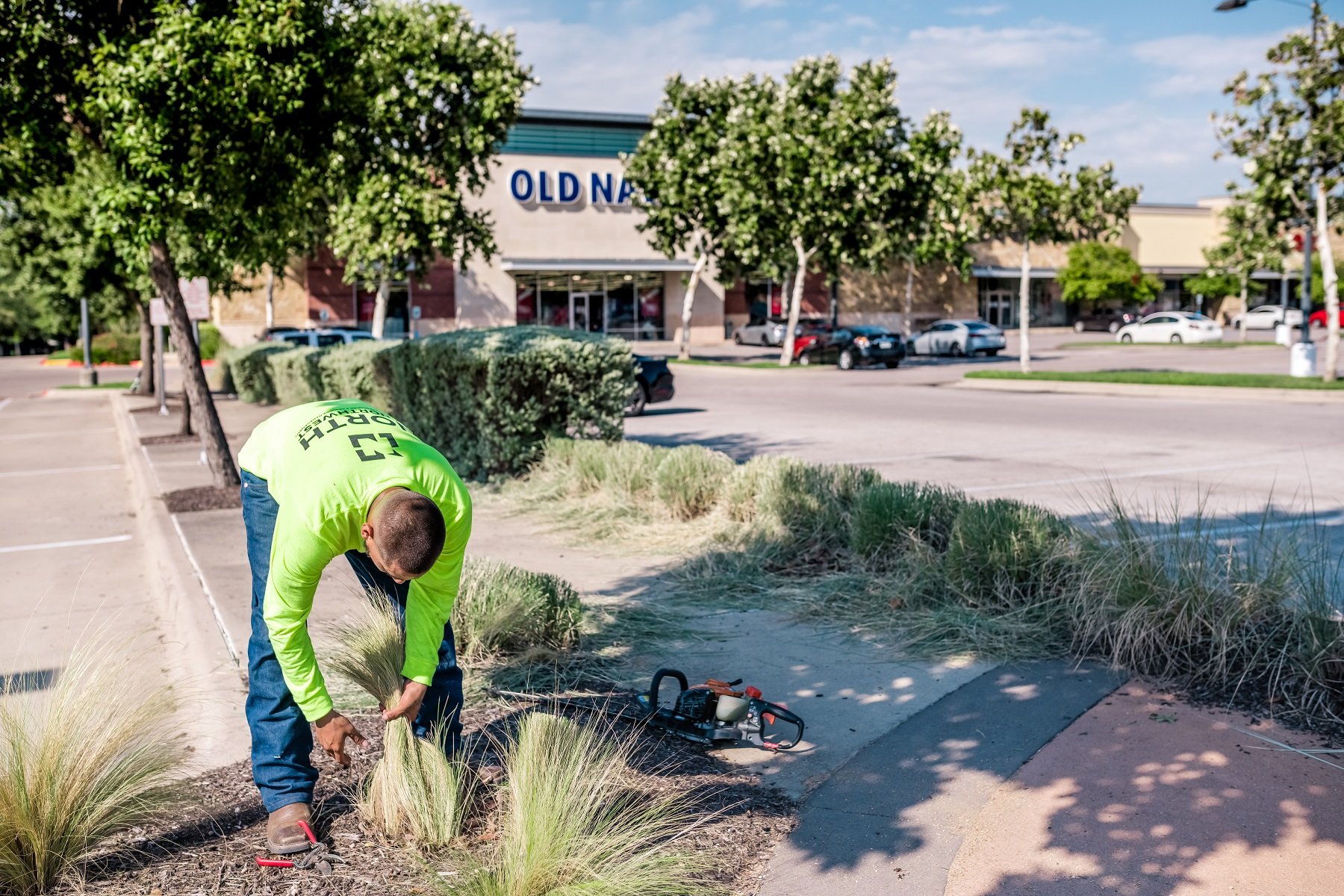 Landscape maintenance crew trimming back grasses