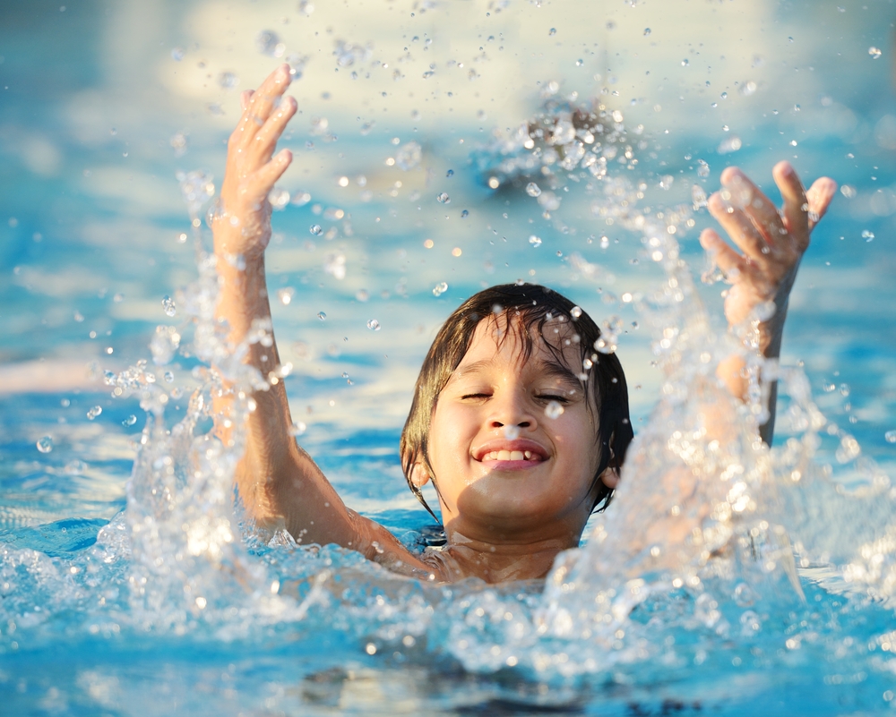 Kid splashing on summer pool