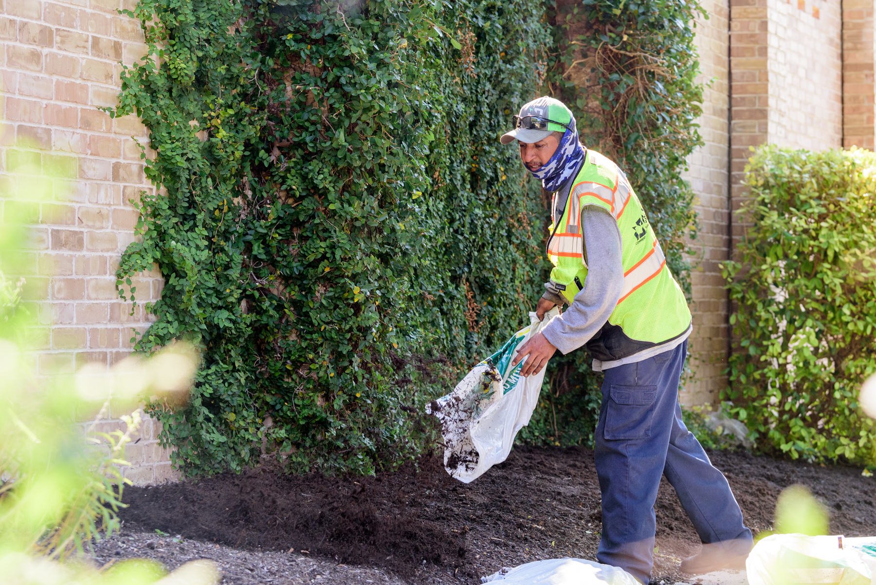 Landscape crew adding mulch to a garden bed